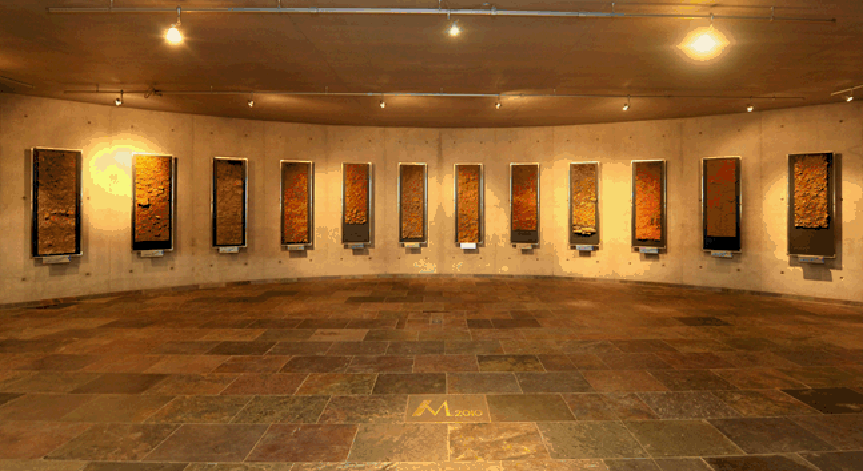 Halbrunder Raum mit zwoelf gerahmten Profilbildern an der Wand